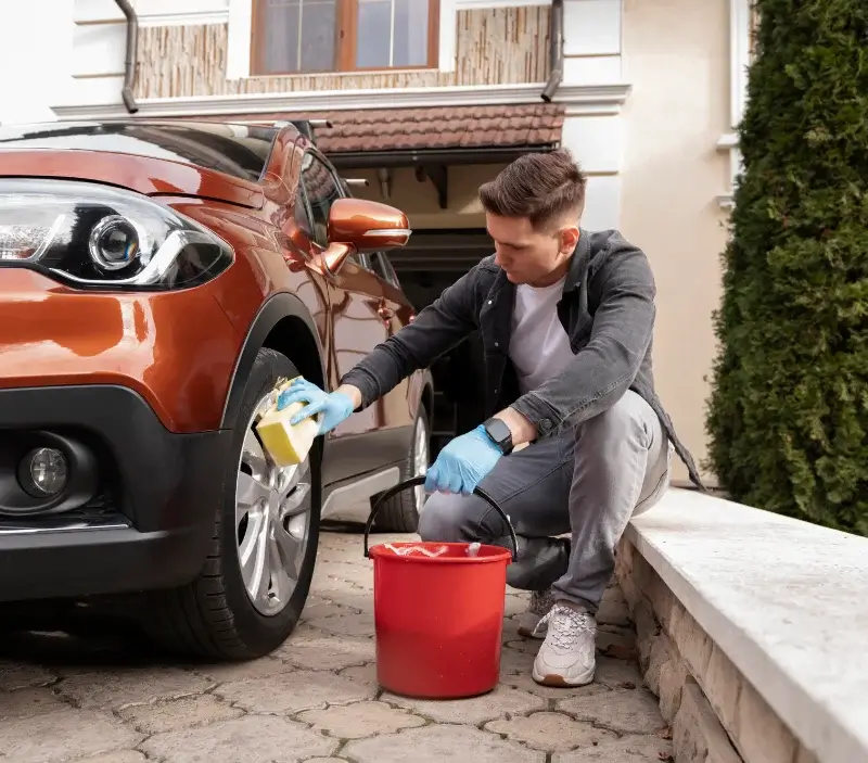 Lavage auto à domicile Greneville-en-Beauce : professionnel intervenant sur un véhicule